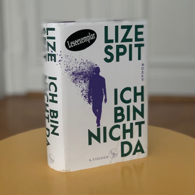 Ein Buch mit dem Titel „Ich Bin Nicht Da“ von Lize Spit mit weißem Einband und grünem Text, darauf die Silhouette einer gehenden Person in Lila.